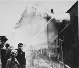 As the synagogue in Oberramstadt burns during Kristallnacht (the "Night of Broken Glass"), firefighters instead save a nearby house. Local residents watch as the synagogue is destroyed. Oberramstadt, Germany, November 9-10, 1938.