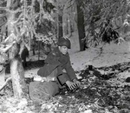A soldier prepares to bed down for the night in a Belgian forest during the Battle of the Bulge. December 21, 1944. US Army Signal Corps photograph taken by J Malan Heslop.