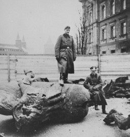 A German soldier stands on a toppled Polish monument. [LCID: 50312]