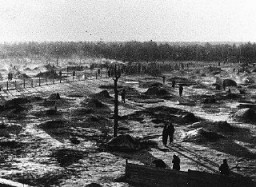 View of a camp for Soviet prisoners of war, showing the holes dug into the ground that served as shelter. The camp was located south of Hamburg in northern Germany. Wietzendorf, Germany, 1941–42.