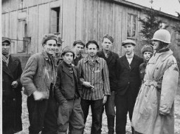 A US army officer (far right) poses with survivors of the Ohrdruf camp, a subcamp in the Buchenwald camp system. Photograph taken after the liberation of the camp. Ohrdruf, Germany, April 1945.