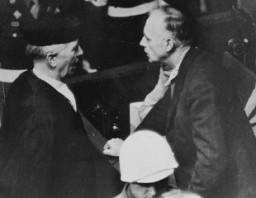 Joachim von Ribbentrop (ministro de Relaciones Exteriores de Alemania de 1938 a 1945) habla con su abogado, el Dr. Fritz Sauter, en la sala del tribunal de Núremberg.