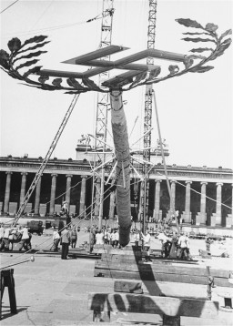 A  Maypole topped with a swastika is raised for a May Day parade in the Lustgarten in Berlin. [LCID: 83796]