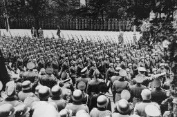 Adolf Hitler (lower right) gives Nazi salute as he reviews victorious German troops. [LCID: 70041]