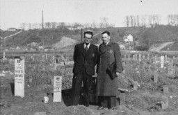 Secretary of the Kovno ghetto Jewish council Avraham Tory stands with Zvi Brik (left), workshop administrator, in the cemetery of the Kovno ghetto. Kovno, Lithuania, 1943.