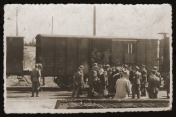 SS personnel stand guard while Lodz ghetto police board Jews onto a deportation train bound for Chelmno or Auschwitz. [LCID: 30037]
