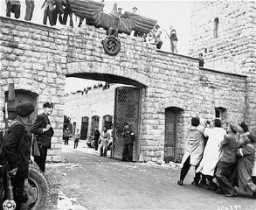 Après la libération du camp de concentration de Mauthausen, des survivants abattent l’aigle nazi au-dessus du portail d’entrée ...