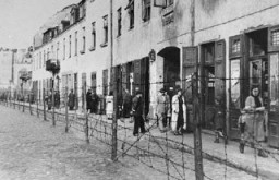 خار دار تاروں کی باڑ کا منظر جو کراکاؤ کی یہودی بستی کے ایک حصے کو شہر کے باقی حصوں سے الگ کرتی تھی۔ کراکاؤ، پولینڈ، تاریخ نامعلوم۔