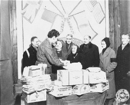 Harry Weinsaft, representante del Comité para la Distribución Conjunta, entrega paquetes de ayuda a refugiados judíos. Viena, Austria, posguerra.
