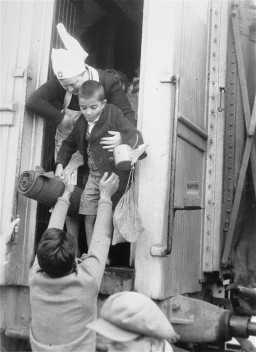 A nurse helps one of the "Tehran Children," Polish Jewish refugees, disembark from a train at the Atlit absorption center. [LCID: 07155]