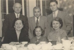 Thomas (standing, right), then known as "Tommy," with relatives shortly after arriving in the United States. [LCID: buerg17]