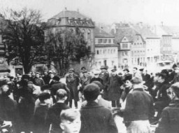 <p>یهودیان در شهر کیتسینگن آلمان، واقع در شمال غربی مونیخ، برای تبعید شدن جمع شده اند. کیتسینگن، آلمان، مارس 1942.</p>