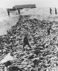 集団墓地の死体の山の中に立つ元収容所医師で囚人に対する人体実験を行ったフリッツ・クライン博士。 1945年4月15日以降、ドイツ、ベルゲン・ベルゼン。