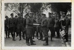 El 1 de septiembre de 1944, Richard Baer acepta ceremonialmente del Jefe del Consejo Central de Construcción de las Waffen SS, SS-Sturmbannführer Karl Bischoff, una copia de los planos de construcción, celebrando la inauguración de un hospital militar (SS-Lazarette).