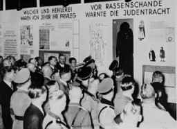 Nazi officials attend the opening of "Der ewige Jude" (The Eternal Jew), an antisemitic exhibition in Munich. The exhibit segment on the left claims that "usury and the fencing of goods" were always the "privilege" of Jews. Munich, Germany, November 8, 1937.