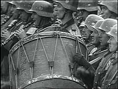 L'Allemagne envahit la Pologne le 1er septembre 1939. Le Blitzkrieg ("guerre éclair") de Pologne fut bref et décisif. Varsovie, capitale de la Pologne, capitula le 27 septembre. Début octobre, Hitler se rendit à Varsovie pour passer ses troupes en revue. Ces images montrent des unités de l'armée allemande victorieuse défilant devant Hitler dans les rues de la ville dévastée.