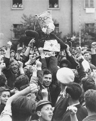 آوارگان علیه بازگشت اجباری مسافران کشتی پناهندگان "اکسودوس 1947" به آلمان اعتراض می کنند. آدمک وزیر امور خارجه بریتانیا، ارنست بوین، به دار آویخته شده است. عکس از هنری ریس. هوئنه-بلزن، آلمان، 7 سپتامبر 1947.