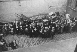 Ebrei tedeschi con in mano cartelli identificativi, in attesa di essere deportati a Theresienstadt. Wiesbaden, Germania, agosto 1942.