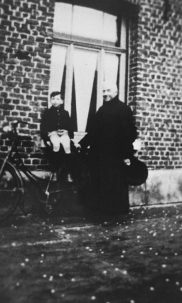 A Jewish child, Jacky Borzykowski, with the priest who placed him in hiding on a farm. [LCID: 04989]