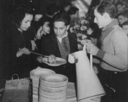 Des enfants arrivés en Grande-Bretagne dans un transport d’enfants (Kindertransport) venant d’Allemagne et d’Autriche prennent un repas à Harwich. Grande-Bretagne, 14 décembre 1938.