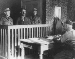 Des membres des SA (Sturmabteilung, sections d’assaut) interrogent un prisonnier fraîchement arrivé dans le camp d’Oranienburg ...