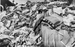Piles of prayer shawls that belonged to Jewish victims, found after the liberation of the Auschwitz camp. [LCID: 85743]
