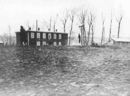 Dans le ghetto de Kovno, le cadavre d’un Juif exécuté sur ordre des Allemands pend à une potence érigée près du bâtiment ...