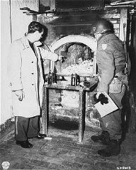 After the liberation of the Flossenbürg camp, a US Army officer (right) examines a crematorium oven in which Flossenbürg camp victims were cremated. Flossenbürg, Germany, April 30, 1945.