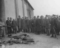 A US soldier stands guard as mayors and citizens of local towns view the corpses of inmates of the Rottleberode subcamp of Dora-Mittelbau, who were killed when the SS locked them in a barn and set it on fire. Gardelegen, Germany, April 18, 1945.