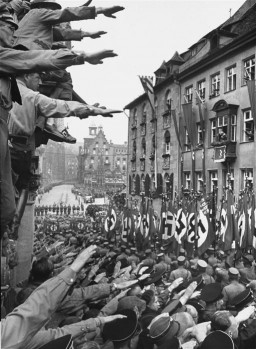 Los espectadores vitorean a las formaciones de las SA que pasan durante un desfile de Reichsparteitag (aniversario de la creación del partido Reich) en Nuremberg.