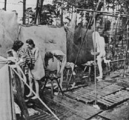 Peu après la libération, des survivants des camps se douchent dans des installations d’extérieur mises en place par les Britanniques.