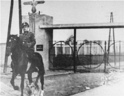 SS Second Lieutenant Gustav Willhaus, camp commandant, rides past the main gate of the Janowska concentration camp. The road from the street and into the camp was paved with tombstones the Nazis removed from Jewish cemeteries. Janowska, Poland, between September 1942 and November 1943.