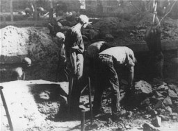 Prisioneros que realizan trabajos forzados y pican piedra con picos en la cantera del campo de concentración de Flossenbürg.