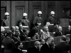 フィルム映像の「ナチス強制収容所」は、1945年11月29日に法廷で提示され、裁判で証拠として用いられました。連合軍が強制収容所を解放した時に撮影されたこのフィルム映像は、1945年11月29日に法廷で提示され、裁判で証拠として用いられました。この一場面は、映像上映後の被告側と法廷にいる人々の反応を示しています。