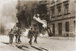 German soldiers burn residential buildings to the ground, one by one, during the Warsaw ghetto uprising. [LCID: 46202]