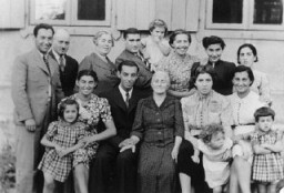 Three generations of a Jewish family pose for a group photograph. Vilna, 1938-39.
The photo was taken during daughter Mina's visit from Montreal. Among those pictured are Mina (Katz) Herman and her daughter, Audrey (front row, second from the right), Itzik Katz, Mina's brother (standing at the far left) and Malka Katz, Mina's mother (front row, center).