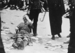 Film still of a woman being dragged by her hair along the ground by an unknown person during the pogrom in German-occupied Lwów on July 1, 1941.