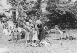 Juifs expulsés de Roumanie vers la Hongrie mangeant dans un champ ouvert. Skala, Hongrie, juillet-août 1941.