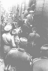 Rendőrök a jászvásári (Iasi) pogromot túlélő román zsidókat kényszerítenek egy vonatra a Jászvásárból Calarasiba való kitoloncolásukkor. Jászvásár (Iasi), Románia, 1941. június vége felé.
