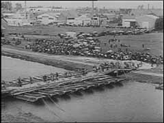 Les forces allemandes envahirent l'Europe occidentale en mai 1940. Dans le cadre de leur stratégie contre la Grande-Bretagne et la France, les forces allemandes envahirent la Belgique, pays neutre. Un peu plus de deux semaines après l'invasion allemande de la Belgique, le roi Léopold II ordonna la capitulation de l'armée belge. Dans ces images, un officier belge signe la capitulation et des milliers de réfugiés affluent dans les rues alors que les forces allemandes avancent en territoire belge.