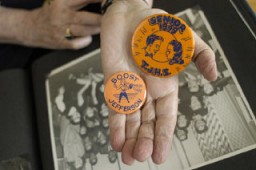 <p>Regina Gelb holds buttons from her high school days.</p>