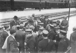 Un grupo de hombres judíos en un andén vigilados por policías franceses en la estación de trenes Austerlitz antes de ser deportados al campo de detención de Pithiviers. París, Francia, mayo de 1941.