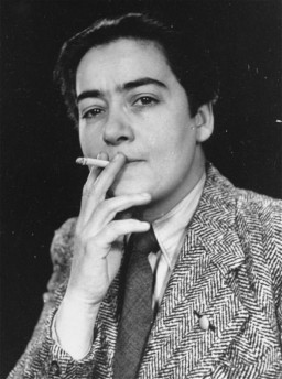 “For three months I was disguised as a man, and very successfully… I passed my mother several times … she never recognized me.”
Frieda Belinfante, a half-Jewish lesbian, used this disguise to hide from Nazi authorities. In a later interview she said, “I really looked pretty good.” 
Her involvement in the resistance movement included planning the destruction of the Amsterdam Population Registry in March 1943, falsifying identity cards, and arranging hiding places for those who were sought by the Nazis.
She was driven to hide herself, after many other members of the Netherlands-based gay resistance group were executed in 1943 by occupying Nazi authorities. In December 1943, Frieda escaped to Switzerland and later immigrated to the United States.
Frieda’s contribution showed the scope of complexity and diversity of the resistance movement to aid others that many faced during the era of the Holocaust. 