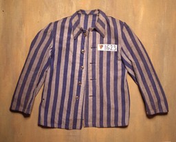 A blue and gray striped jacket from the Flossenbürg concentration camp. The letter "P" on the left front of the jacket indicates that it was worn by a Polish, non-Jewish prisoner. "P" stands for "Pole" in German. The jacket was donated to the United States Holocaust Memorial Museum by the prisoner who wore it, Julian Noga.