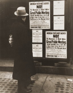 A pedestrian pauses to read a notice announcing an upcoming public meeting, scheduled for Tuesday, December 3, to urge Americans ... [LCID: oly106]