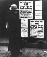 Un piéton s'arrête pour lire une affiche qui annonce une assemblée publique le mardi 3 décembre incitant les Américains à boycotter les Jeux olympiques de Berlin de 1936. New York, États-Unis, 1935.