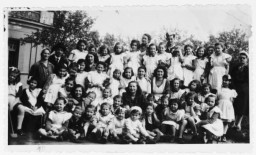 Zsofi Brunn (back row, center) poses with the orphans (previously hidden children) under her care in a JDC-sponsored orphanage outside of Budapest.