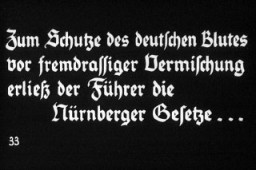 ۳۳ امین اسلاید تبلیغات نازی مربوط به یک ارائه آموزشی جوانان هیتلر با عنوان "آلمان بر یهودیت غلبه می کند". متن به زبان آلمانی می‌گوید