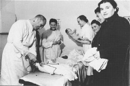 Equipe médica atende a bebês na clínica infantil do campo para deslocados de guerra de Zeilsheim, localizado na area de ocupação norte-americana na Alemanha.  Zeilsheim, Alemanha.  Foto tirada após a Guerra.