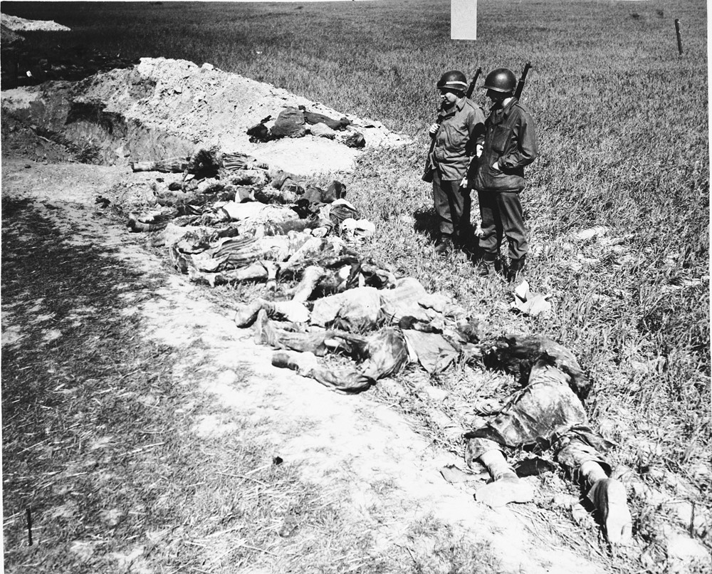 American soldiers look at the exhumed bodies of prisoners who were burned alive in a barn outside Gardelegen. [LCID: 89068]